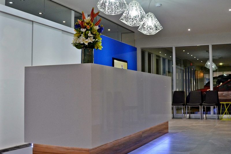 Custom built bespoke office interior featuring a beautiful reception counter and lighting